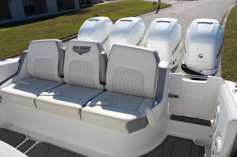 Slide: The Image of 2019 Deep Impact 399 Sport boat with triple outboard engines and cushioned seating. - 36