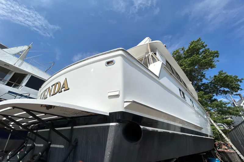 Slide: The Image of 1991 Hatteras Cockpit Motor Yacht on dry dock under clear blue sky. - 1