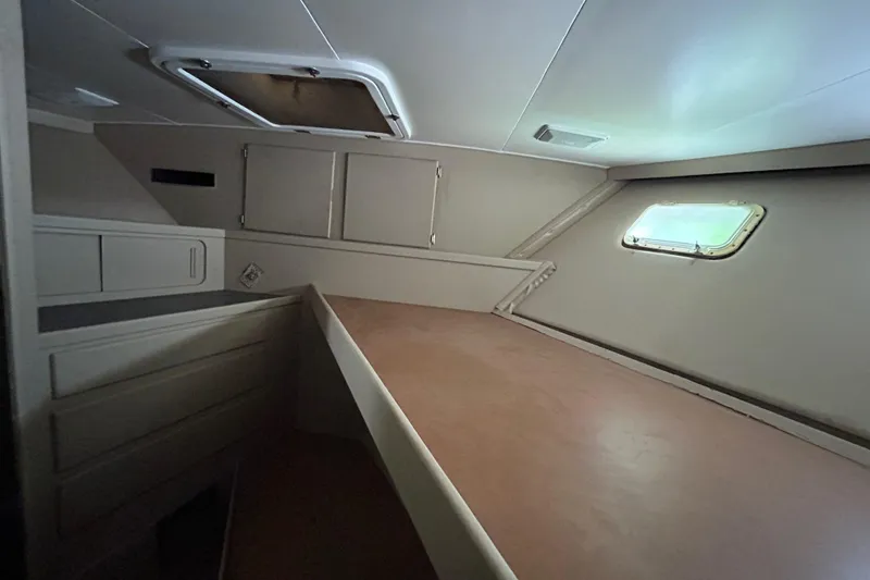 Slide: The Image of Interior cabin of 1991 Hatteras Cockpit Motor Yacht, featuring a bed and storage compartments. - 11