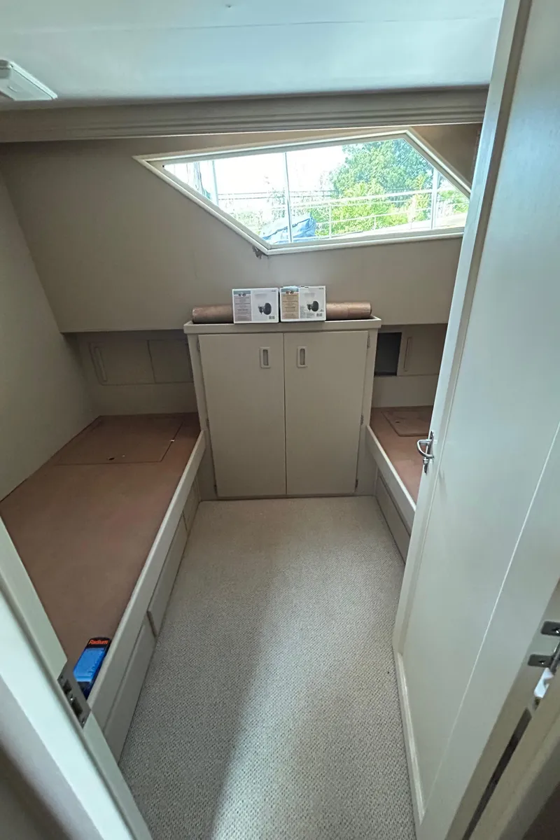 Slide: The Image of 1991 Hatteras Cockpit Motor Yacht cabin with twin beds and storage cabinet. - 14