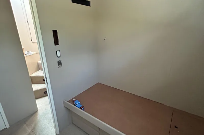 Slide: The Image of 1991 Hatteras Cockpit Motor Yacht interior with bed and stairs, minimalist design. - 17