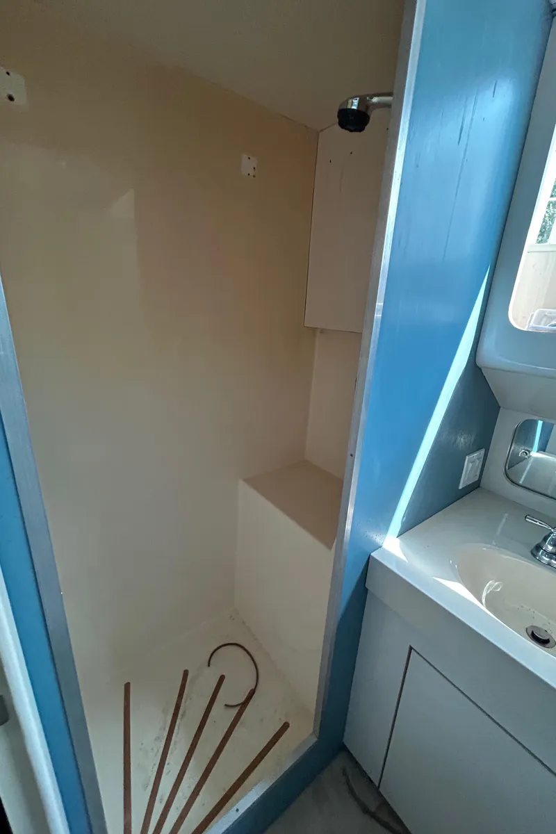 Slide: The Image of Shower area in 1991 Hatteras Cockpit Motor Yacht with blue accents and sink. - 19