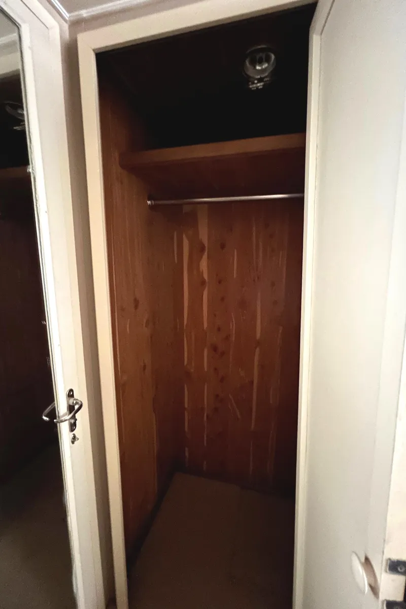 Slide: The Image of Empty wooden closet inside a 1991 Hatteras Cockpit Motor Yacht. - 26