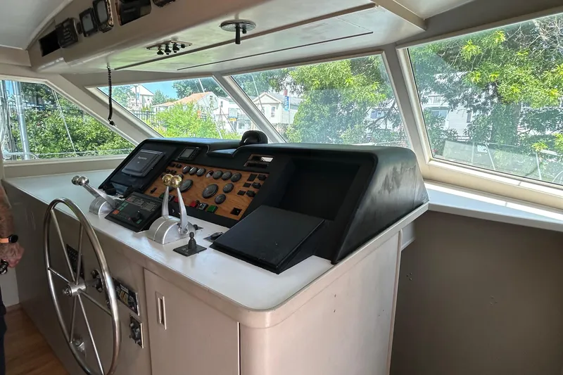 Slide: The Image of 1991 Hatteras Cockpit Motor Yacht helm with steering wheel and control panel. - 29