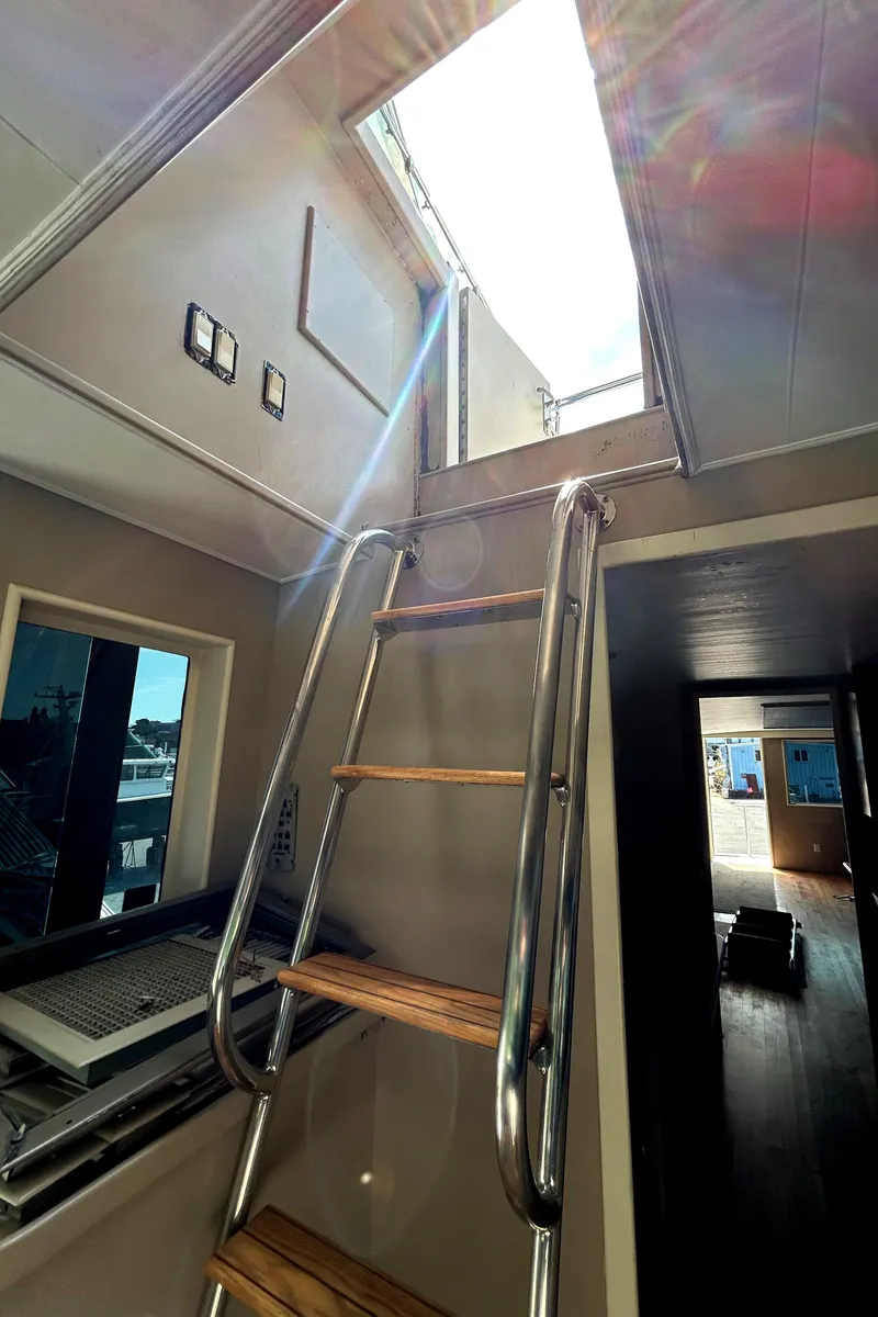 Slide: The Image of Interior view of 1991 Hatteras Cockpit Motor Yacht ladder leading to open hatch. - 30