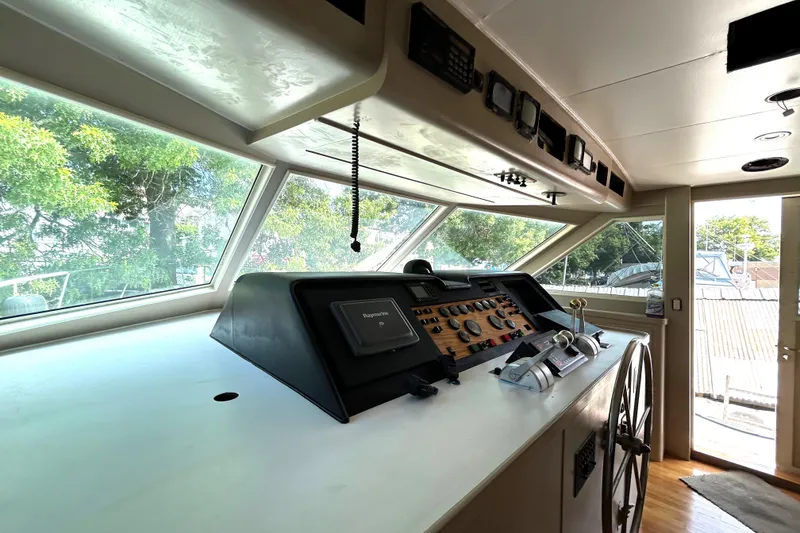 Slide: The Image of 1991 Hatteras Cockpit Motor Yacht helm with navigation controls and panoramic windows. - 32