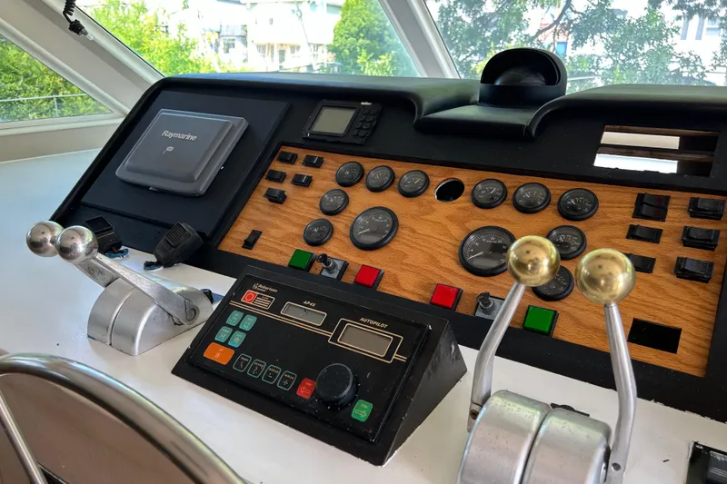 Slide: The Image of Control panel of a 1991 Hatteras Cockpit Motor Yacht with gauges and levers. - 33