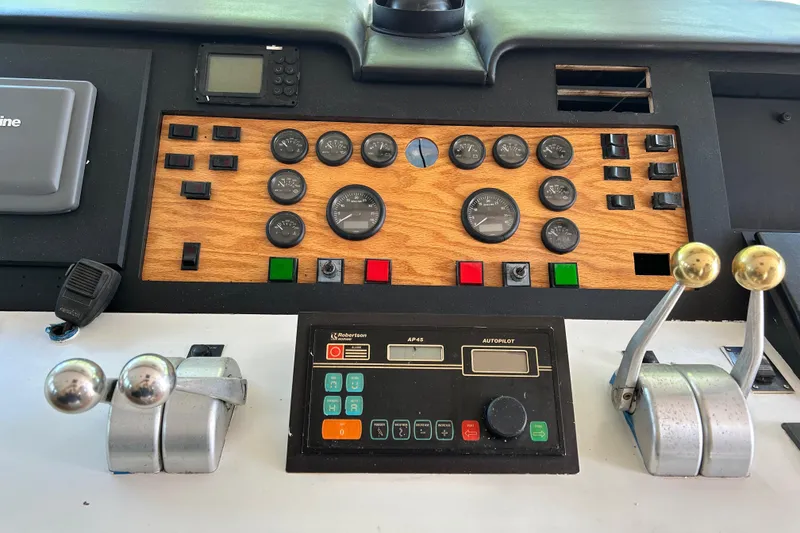 Slide: The Image of Control panel of a 1991 Hatteras Cockpit Motor Yacht with gauges and levers. - 35