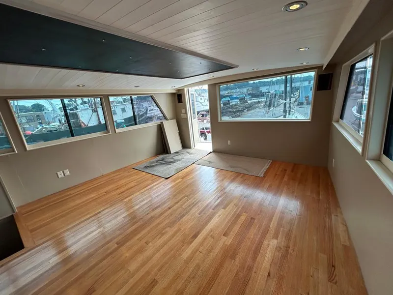 Slide: The Image of Spacious interior of 1991 Hatteras Cockpit Motor Yacht with wooden flooring and large windows. - 4