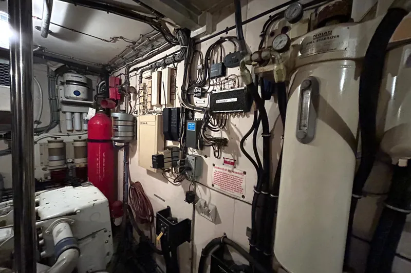 Slide: The Image of Engine room of a 1991 Hatteras Cockpit Motor Yacht with various equipment and machinery. - 45