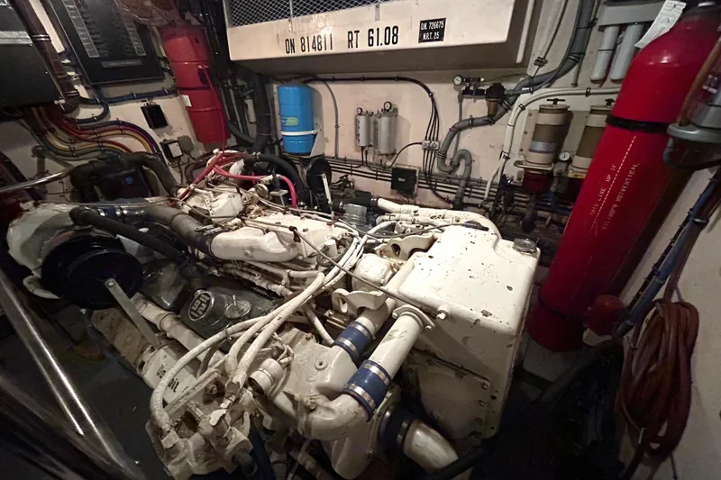 Slide: The Image of Engine room of a 1991 Hatteras Cockpit Motor Yacht, showcasing complex machinery and wiring. - 46