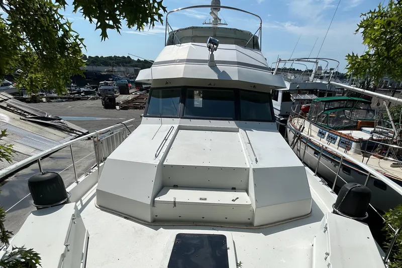 Slide: The Image of 1991 Hatteras Cockpit Motor Yacht docked, showcasing sleek design and spacious deck. - 49