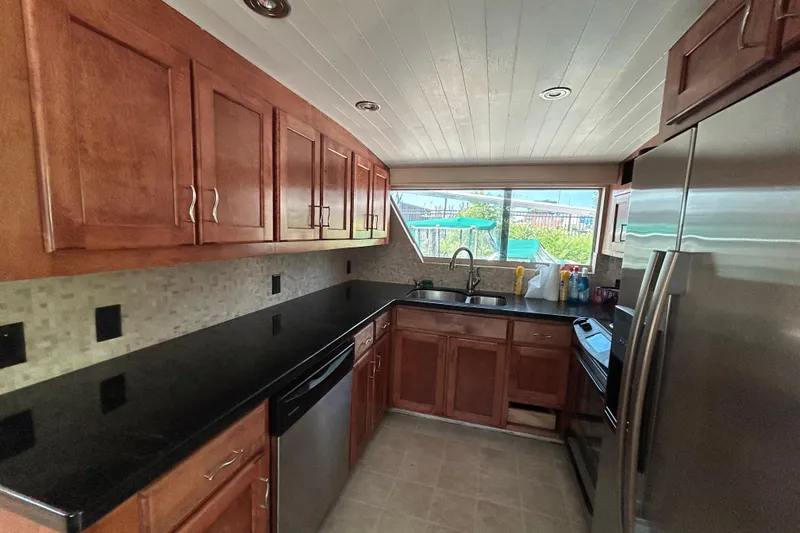 Slide: The Image of Spacious kitchen in 1991 Hatteras Cockpit Motor Yacht with modern appliances and wooden cabinetry. - 5