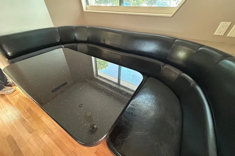 Slide: The Image of Luxurious black leather seating with a sleek table on a 1991 Hatteras Cockpit Motor Yacht. - 6