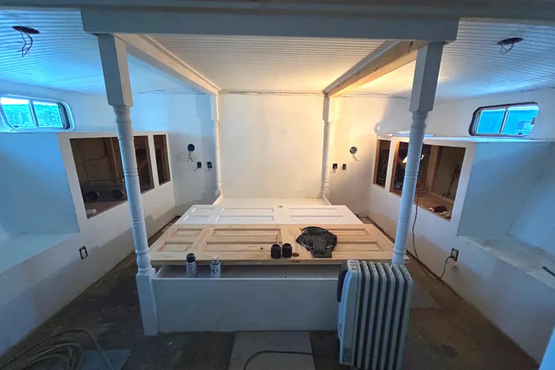 Slide: The Image of Interior of 1991 Hatteras Cockpit Motor Yacht under renovation, featuring white walls and windows. - 7