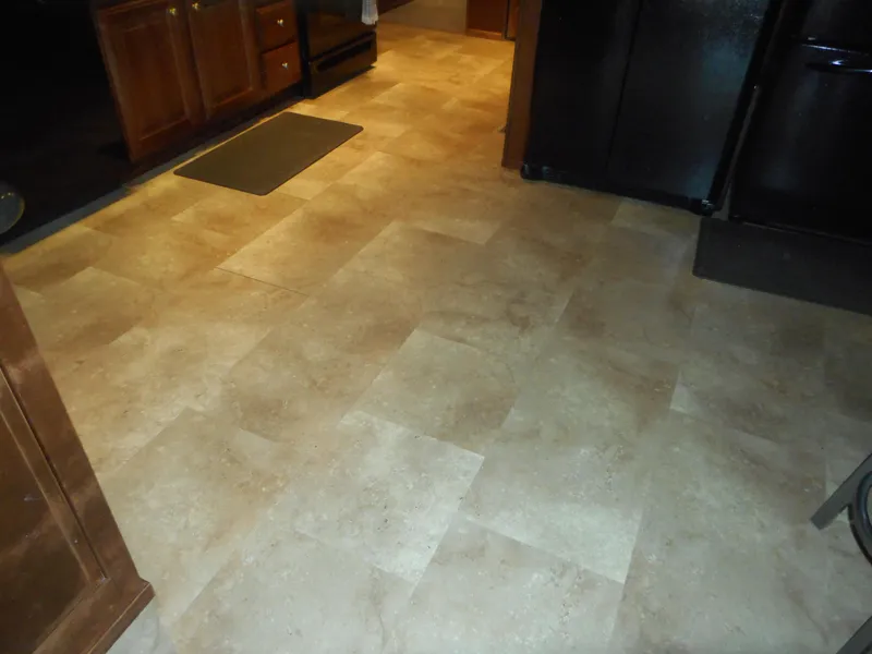 Slide: The Image of Kitchen floor with beige tile pattern, dark cabinets, and appliances. - 34