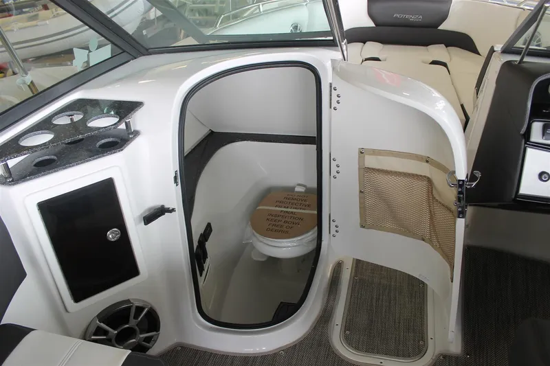 Slide: The Image of 2018 Bryant Potenza boat interior with open bathroom door, showcasing compact toilet and seating area. - 14