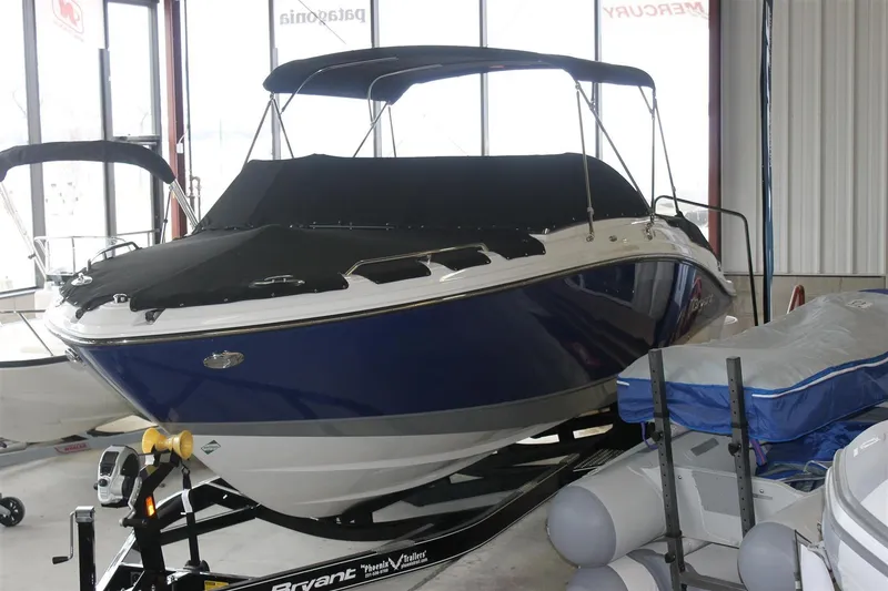 Slide: The Image of 2018 Bryant Potenza boat with blue hull and black cover in showroom. - 3