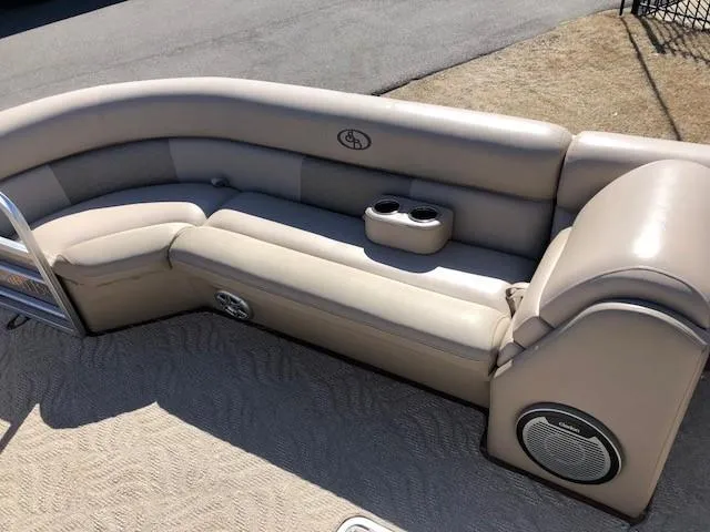 Slide: The Image of 2013 South Bay 726 CR boat seating with beige upholstery and built-in cup holders. - 16