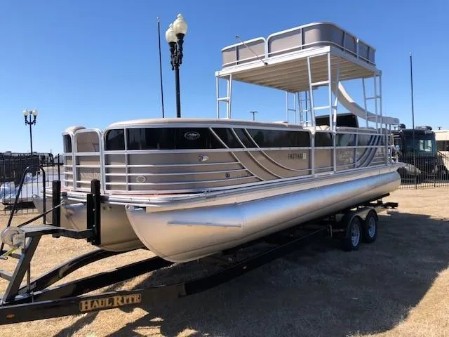 Slide: The Image of 2013 South Bay 726 CR pontoon boat on trailer, parked outdoors under clear sky. - 4