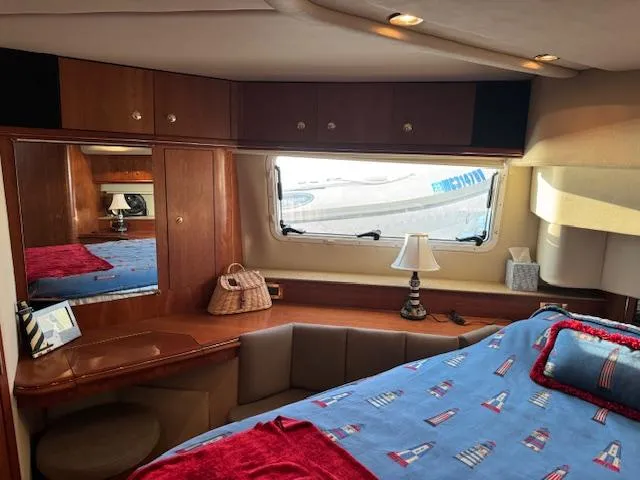 Slide: The Image of Luxurious 2000 Cruisers Yachts 4450 Express Motor Yacht cabin interior with nautical-themed bedding. - 32