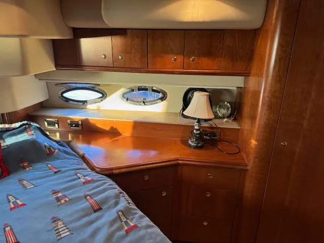 Slide: The Image of Interior of 2000 Cruisers Yachts 4450 Express Motor Yacht with wood cabinetry and nautical-themed bedding. - 34