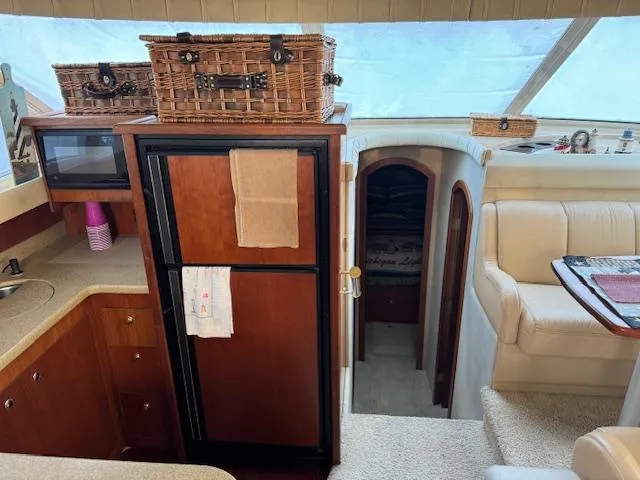 Slide: The Image of Interior of 2000 Cruisers Yachts 4450 Express Motor Yacht, featuring kitchen and seating area. - 43