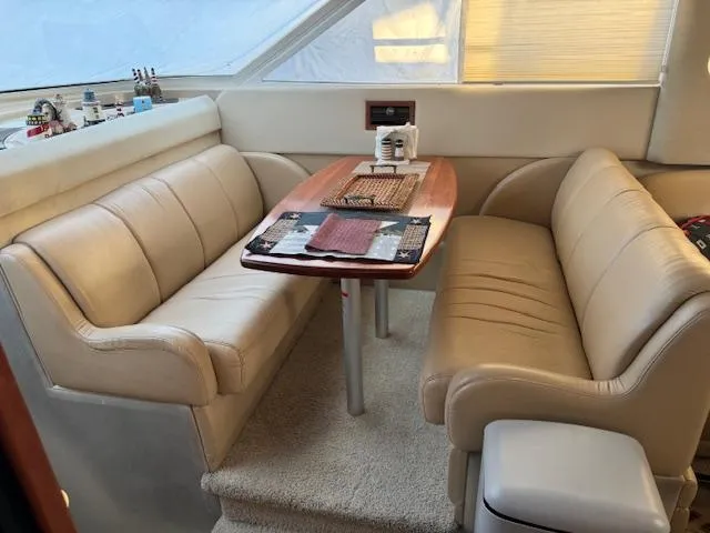 Slide: The Image of Interior of 2000 Cruisers Yachts 4450 Express Motor Yacht with beige seating and wooden table. - 44