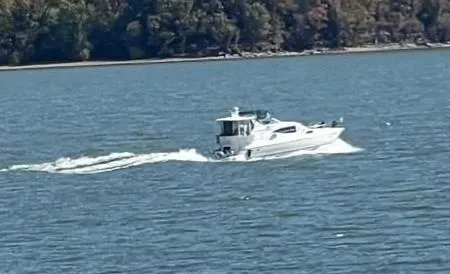 Slide: The Image of 2000 Cruisers Yachts 4450 Express Motor Yacht cruising on a scenic lake. - 6