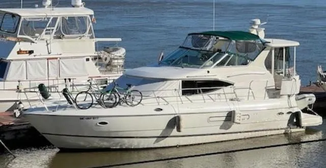 Slide: The Image of 2000 Cruisers Yachts 4450 Express Motor Yacht docked with bicycles on deck. - 1