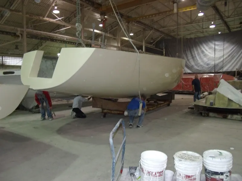 Slide: The Image of Workers assembling Tartan 365 sailboat hull in a factory, 2025 model. - 4