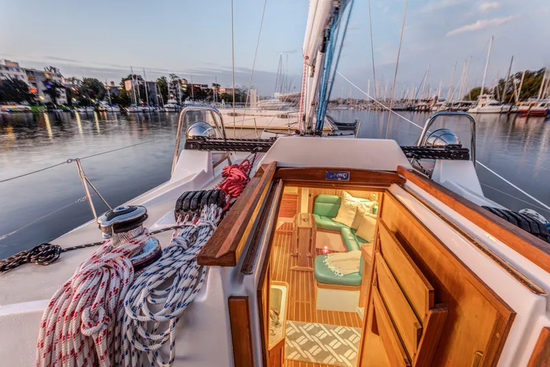 Slide: The Image of Tartan 365 sailboat interior view, docked in a serene marina, 2025 model. - 7