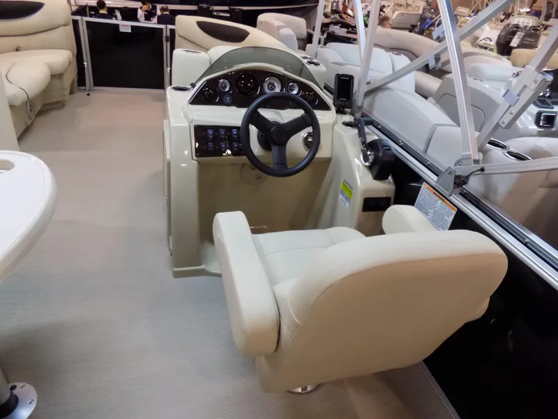 Slide: The Image of 2023 Sylvan 8520 Mirage Cruise boat interior with beige captain's chair and control panel. - 8