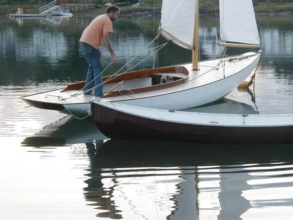 Slide: The Image of Man on Herreshoff Watch Hill 15 sailboat, 1994 model, docked on calm water. - 3