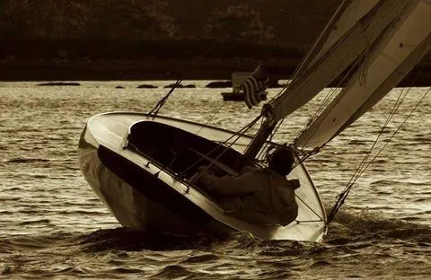 Slide: The Image of Sailing Herreshoff Watch Hill 15, 1994 model, on serene waters at sunset. - 4