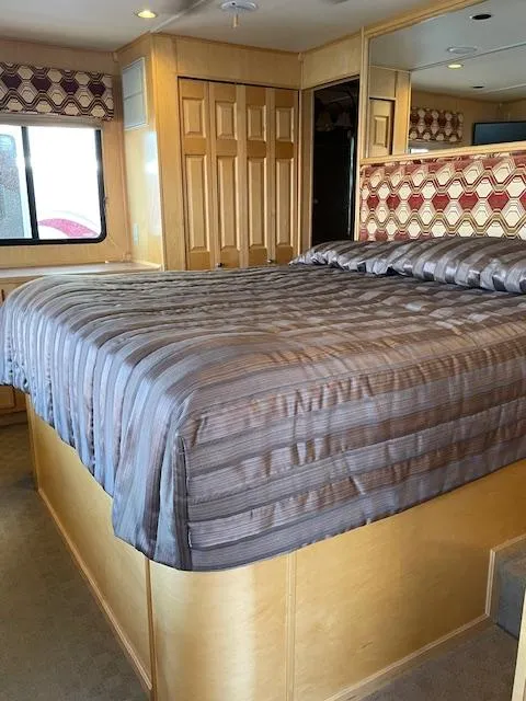 Slide: The Image of 2007 American Waterways Sundancer Trip 16 bedroom with large bed and wooden cabinetry. - 5