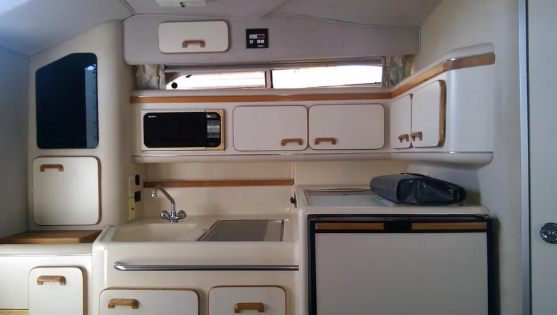 Slide: The Image of 1993 Sea Ray 330 Express Cruiser kitchen with cabinets, sink, and appliances. - 12