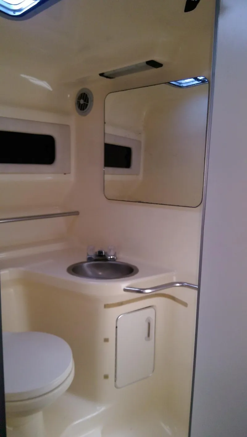 Slide: The Image of 1993 Sea Ray 330 Express Cruiser bathroom with sink, mirror, and toilet. - 14