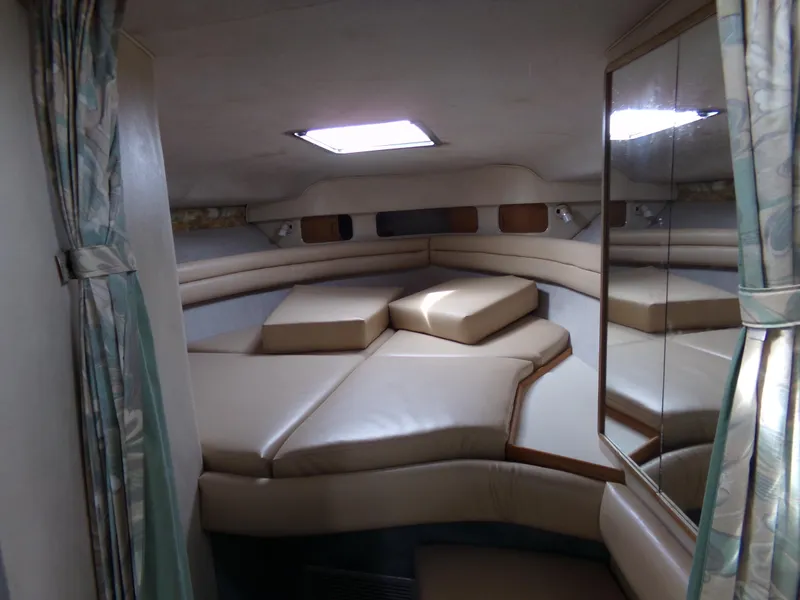 Slide: The Image of 1993 Sea Ray 330 Express Cruiser cabin interior with cushioned seating and skylight. - 15