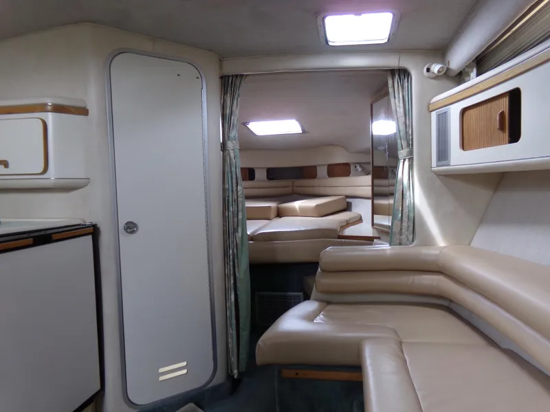 Slide: The Image of Interior of 1993 Sea Ray 330 Express Cruiser with beige seating and cabin amenities. - 17