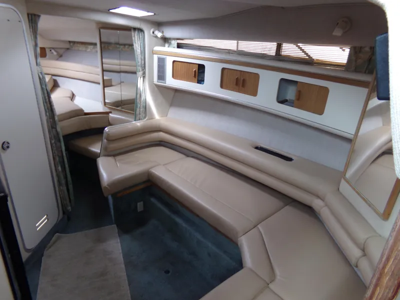 Slide: The Image of 1993 Sea Ray 330 Express Cruiser interior with beige leather seating and wooden storage cabinets. - 19