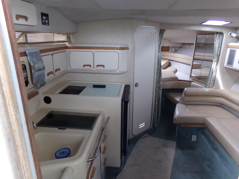 Slide: The Image of 1993 Sea Ray 330 Express Cruiser interior with kitchen and seating area. - 20