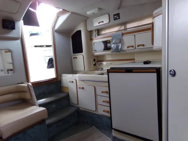 Slide: The Image of Interior of 1993 Sea Ray 330 Express Cruiser with kitchenette and seating area. - 25
