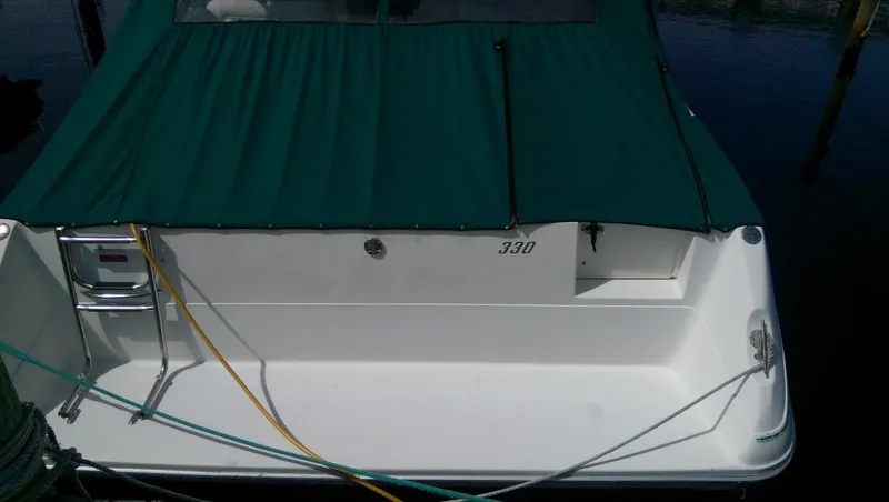 Slide: The Image of 1993 Sea Ray 330 Express Cruiser with green canopy docked. - 4