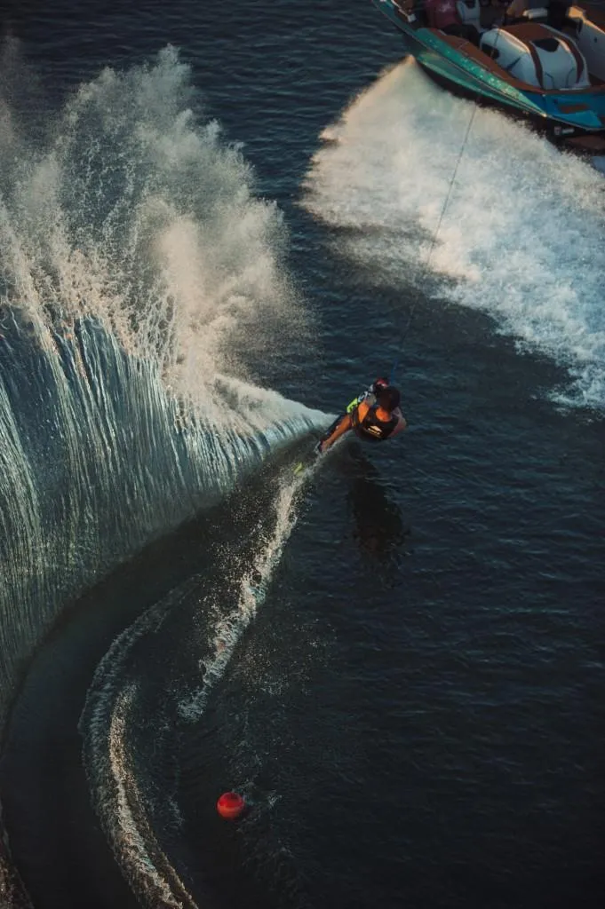 Slide: The Image of 2023 Nautique Ski boat towing a water skier. - 16