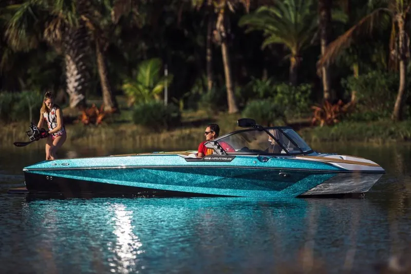 Slide: The Image of 2023 Nautique Ski boat on a tropical lake with a wakeboarder. - 28