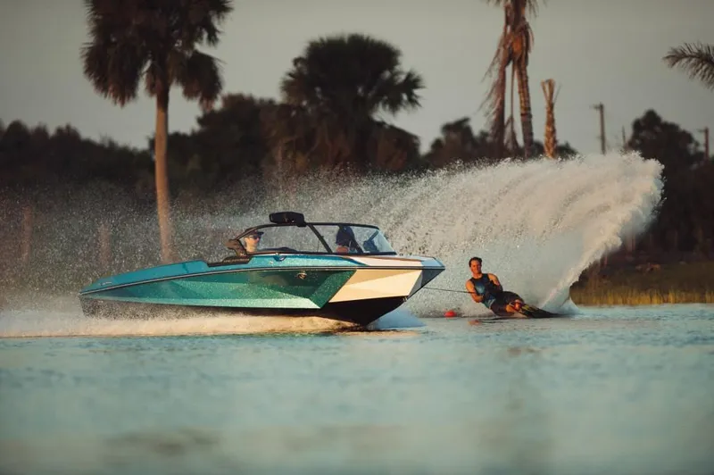 Slide: The Image of 2023 Nautique Ski boat towing a water skier on a sunny day. - 31