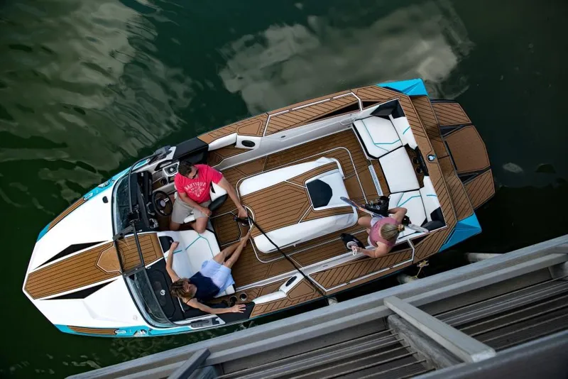 Slide: The Image of 2023 Nautique Ski boat with three people onboard, viewed from above. - 34