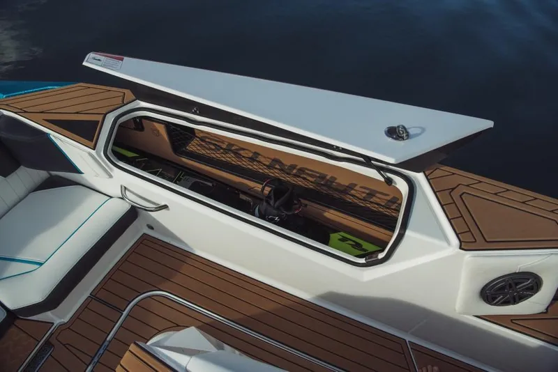 Slide: The Image of 2023 Nautique Ski boat with open storage compartment and teak flooring. - 41