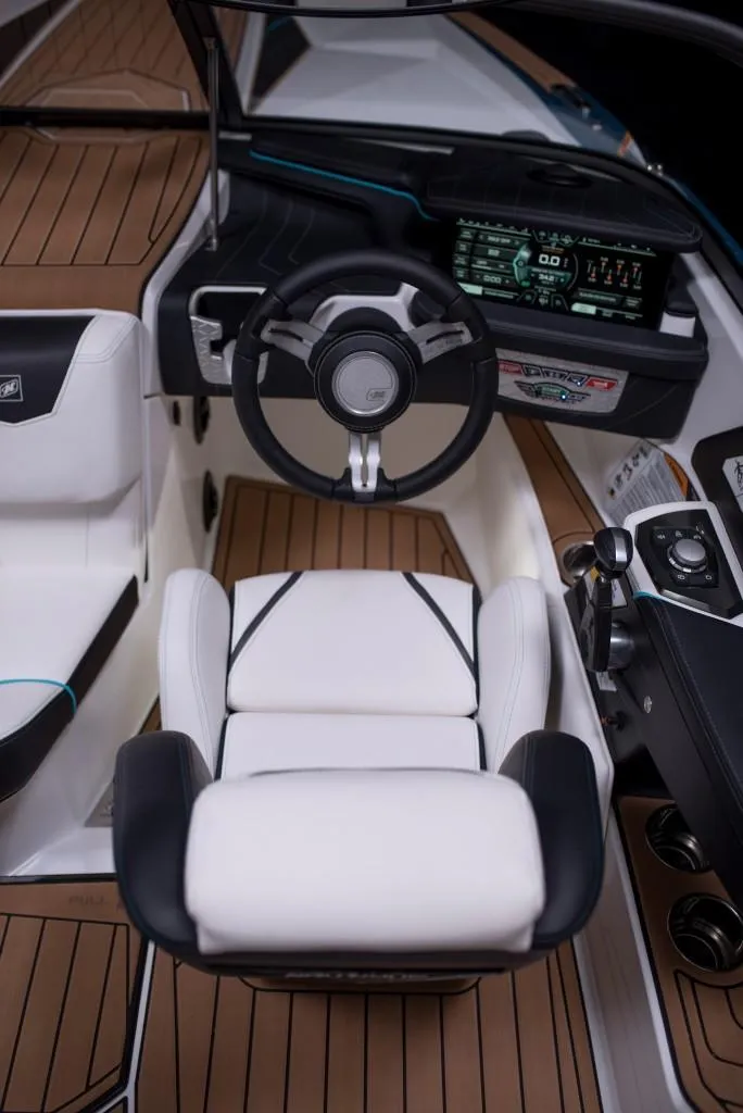 Slide: The Image of 2023 Nautique Ski boat cockpit with modern dashboard and white captain's chair. - 48
